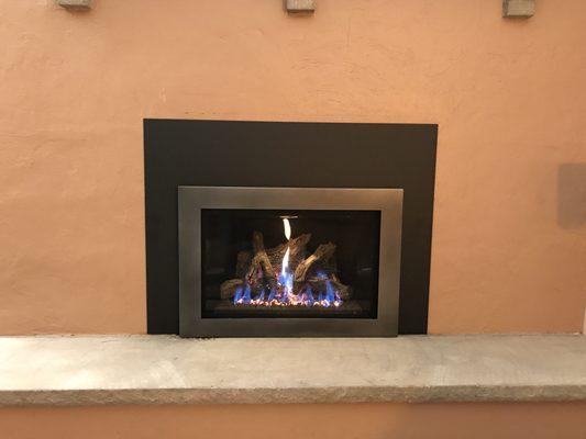 New gas fireplace insert with surround (black) and trim (silver).