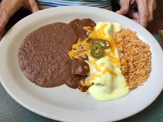 From the Lunch Menu: Beef and chicken enchiladas with rice and refried beans.  Chips and salsa come with the meals.