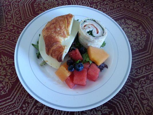 Luncheons for any special occasion - Featured: Ham & Cheese Croissant, Turkey Pinwheel with side of mixed fruit.