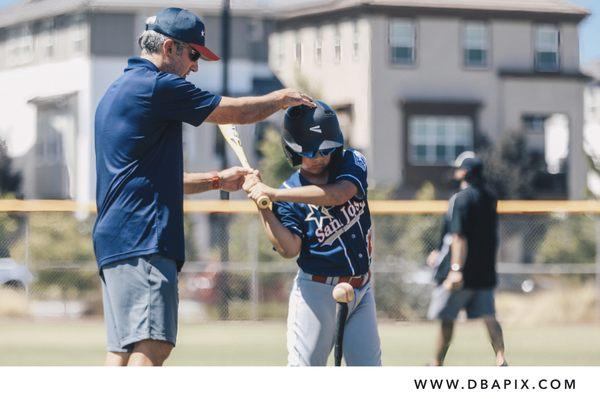 Coach helps a player with batting swing at Arcadia Ballpark in San Jose, CA.