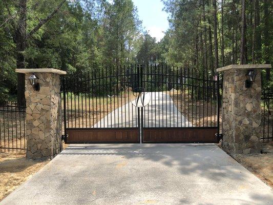 Custom personalized estate gate with stone columns, lighting package, and automation package.