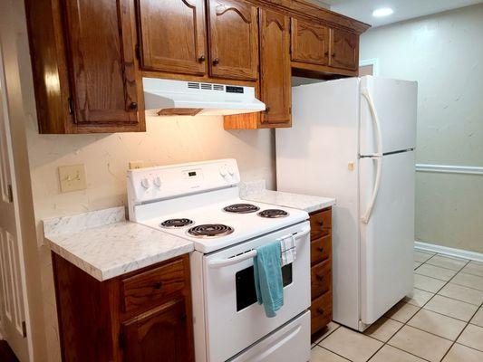 Clean modern kitchen with stove,Refrigerator with ice maker, microwave, and dishwasher.