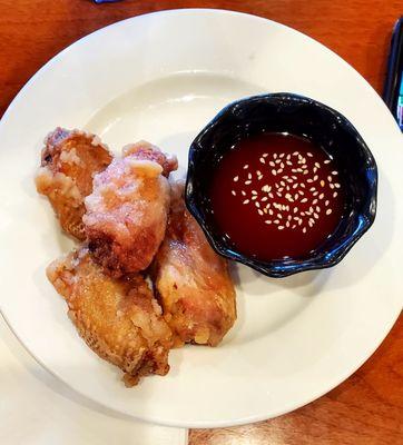 Chicken wings and sauce with sesame seeds.