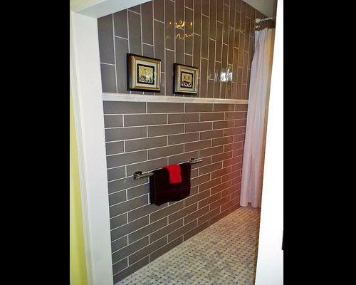 Floor to ceiling subway tiles w-marble floor, chair rail, designer grab-towel bars