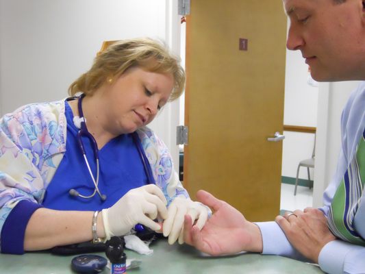 Nurse checking a patient's blood sugar