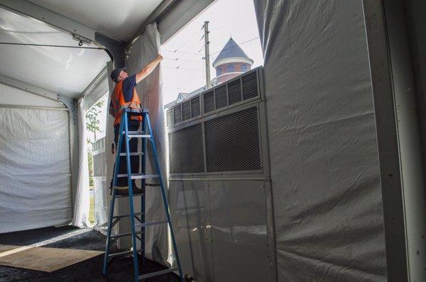 One of our technicians installing some of our vertical HVAC units at an outdoor tented concert.