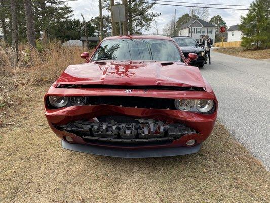 Red Dodge Challenger with front end damage