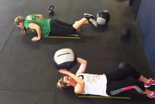 The ladies doing some push-ups, medicine ball sit-ups and kettlebell swings