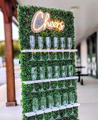 Champagne grass wall stand with glassware and neon sign