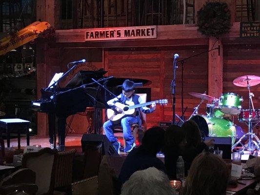 Student performing with his guitar at Dosey Doe!