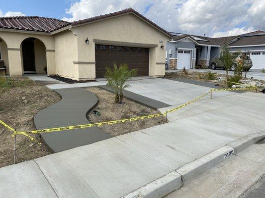 NEW HOME CONSTRUCTIONS W/FRESH CONCRETE SIDEWALK AND DRIVEWAY