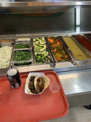 One flour tortilla with barbacoa and one corn tortilla with steak fajita.