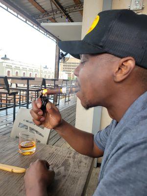 Lighting a cigar with a Bourbon