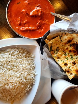 Butter chicken, garlic naan, masala tea and basmati rice.