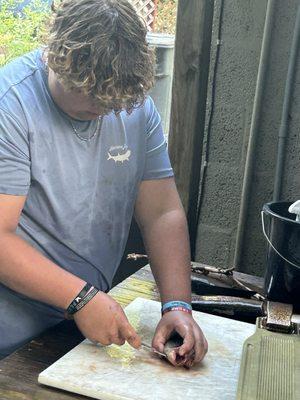 Cleaning his trout that he caught in the river