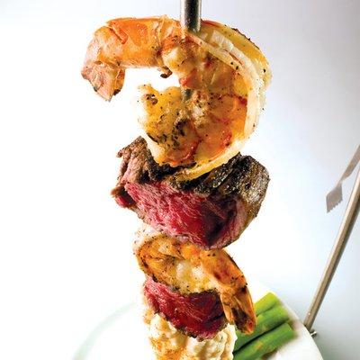 Symphony Kabob a hanging presentation of beef tenderloin, lobster and shrimp served with steamed asparagus