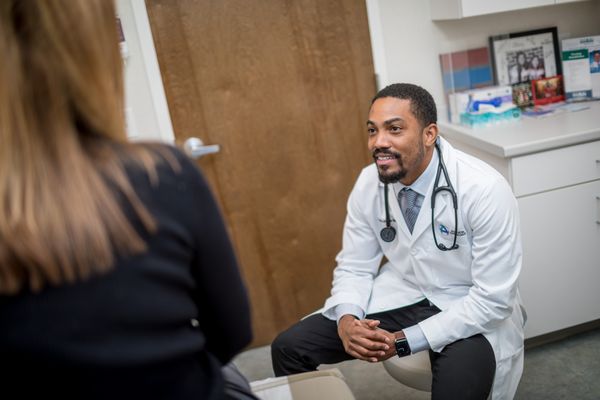 Medical oncologist Dr. JP Blaize talks with a patient during an exam.