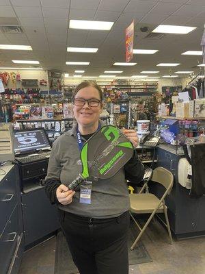 Mary the cashier, holding up my beautiful new pickle ball paddle she researched for my skill level. I love it!   Julie A