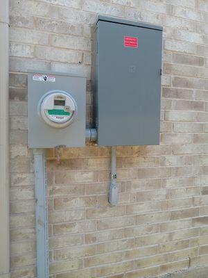 Exterior 200 amp main panel, new 50 amp GFCI circuit, exterior conduit to interior NEMA 14-50 EV charging outlet.