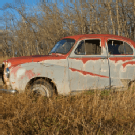 Antique car abandoned in dry grass