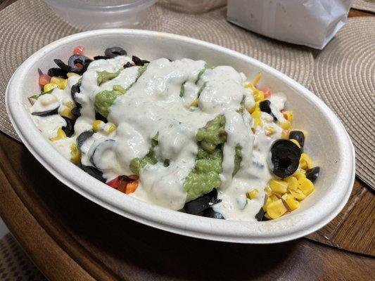 Burrito bowl with cilantro rice, steak, cheese, bell peppers, tomatoes, corn, black olives, guacamole. Topped with avocado ranch.