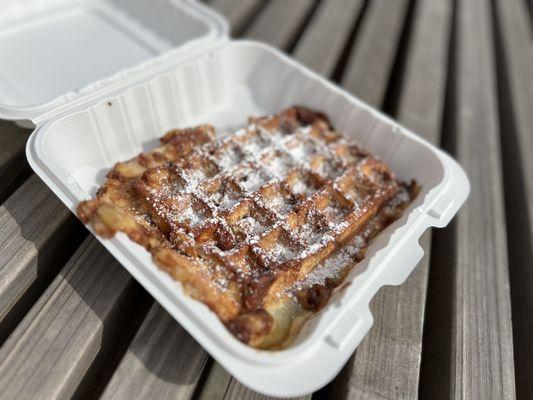 Cinnamon batter waffle in a box on a bench, in a pleasant place for noms.