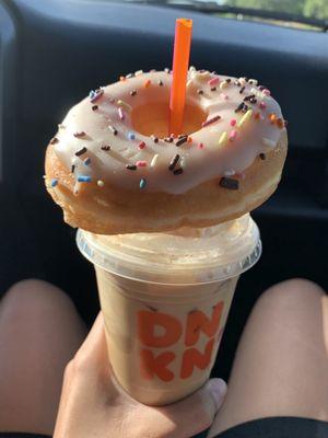 Vanilla frosted donut with sprinkles on top and a caramel craze Iced Latte