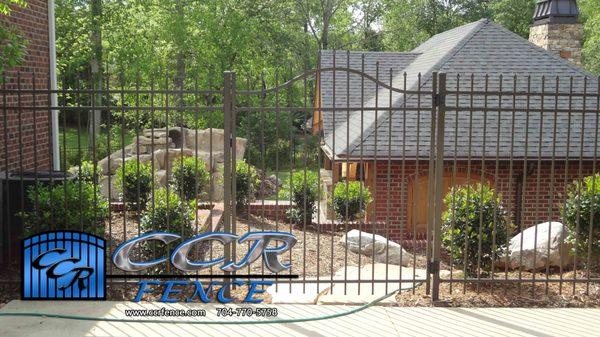 Bronze Aluminum Arched Top Gate that separates driveway from the steps down to Pool House. 5ft Tall Fencing