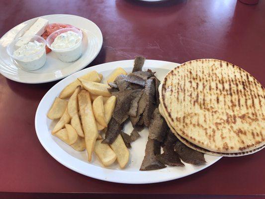 Gyros plate. Very generous portions!! 2 huge pitas are covering half the meat. 2 cups of sauce given. Nice !!