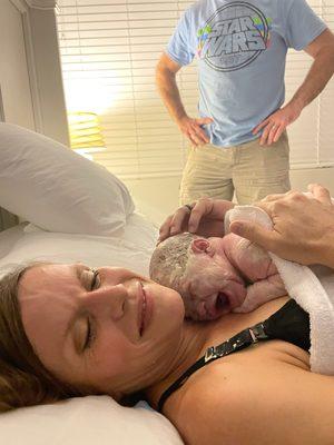 A mother holding her newborn baby that was born in the water at the birth center.