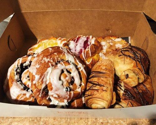 Cinnamon raisin rolls, chocolate croissants, and assorted Danishes.