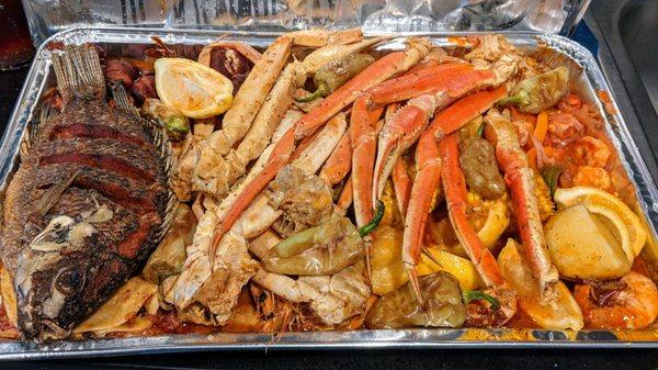 Tray full of fish, crab legs, shrimp, tacos, potatoes, corn, and more. Feeds 8-10 people.