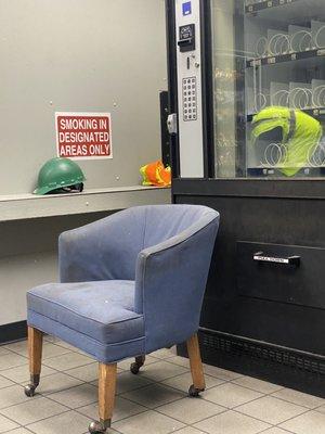 The filthy stained chair with the empty vending machine behind it.