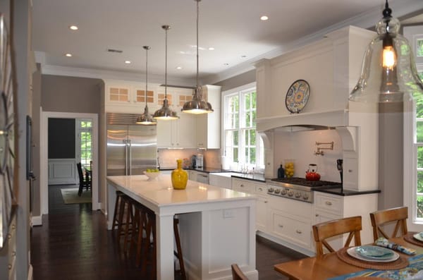 Soft White Painted Cabinets w/ Large Island.  Contrasting Dark Floors.