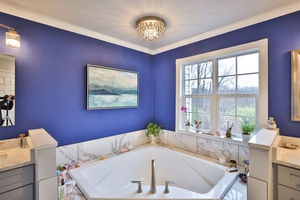 Master bathroom remodel in Frederick with corner bathtub & marble lined tiles