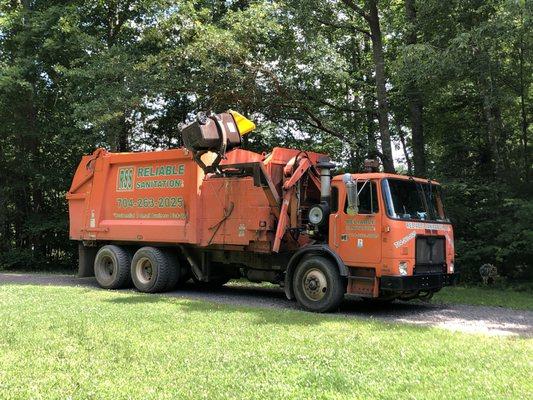 Reliable Sanitation trash truck dumping a 96 gallon curbside kart.