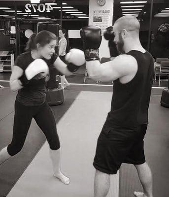 Action shot of our instructors Nicole & Johnny showing the class a Jab Cross  combo