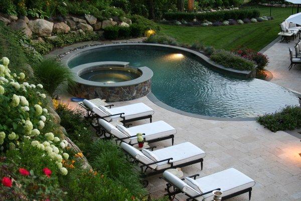 Natural pool environment with spa, infinity edge and travertine terrace.