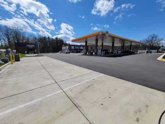 Left side of gas station. Carwash is in the building on the left. Vacuum and air hoses on the left by the yellow barrier poles.