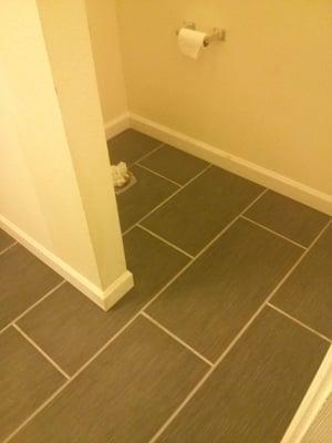 Dark tile laid to match the brick layout of the subway tile.