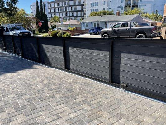 Custom tendon 40 foot sliding gate dressed with black painted clear redwood gate