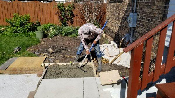 Marcial spreading the concrete for gas grill base