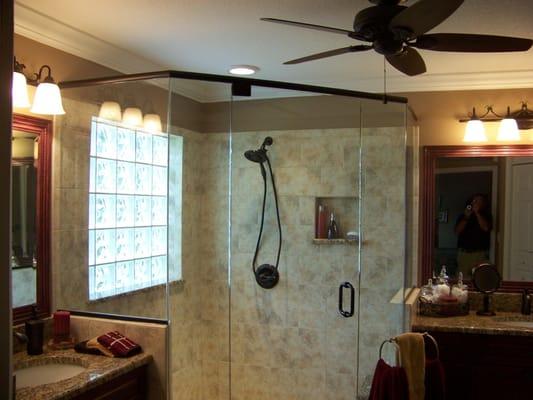 Custom ceramic tile shower w/glass enclosure, surrounded by wood vanities w/Granite countertops on each side.