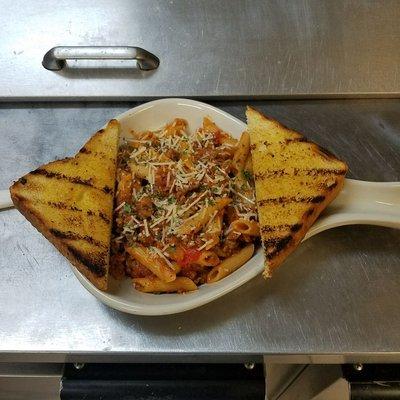 Tonight special homemade pork ragu with penne pasta and garlic toast