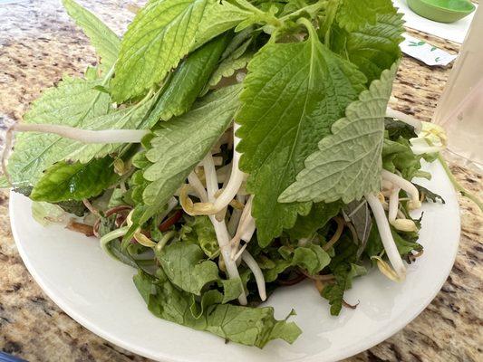 Greens and herbs including banana blossoms and perilla.