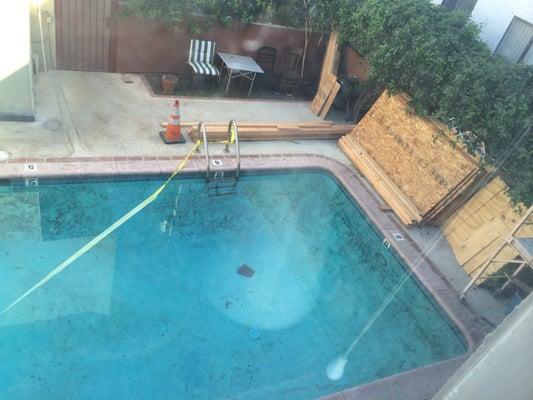 filthy pool with rusted railings. it has been at this level of filth and mold for over a year, never cleaned.