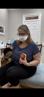 Katherine demonstrating how to hold the breast in preparation of latching baby.