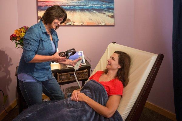 Susan D. getting a client ready for a sound therapy session.