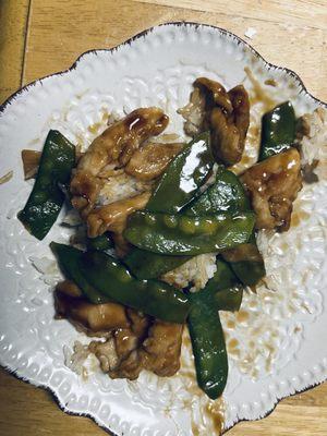 Chicken with peapods on a plate at home.