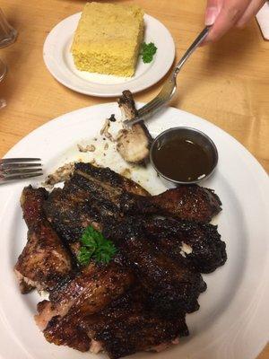 Jerk chicken with sauce. Cornbread at the top of the photo.